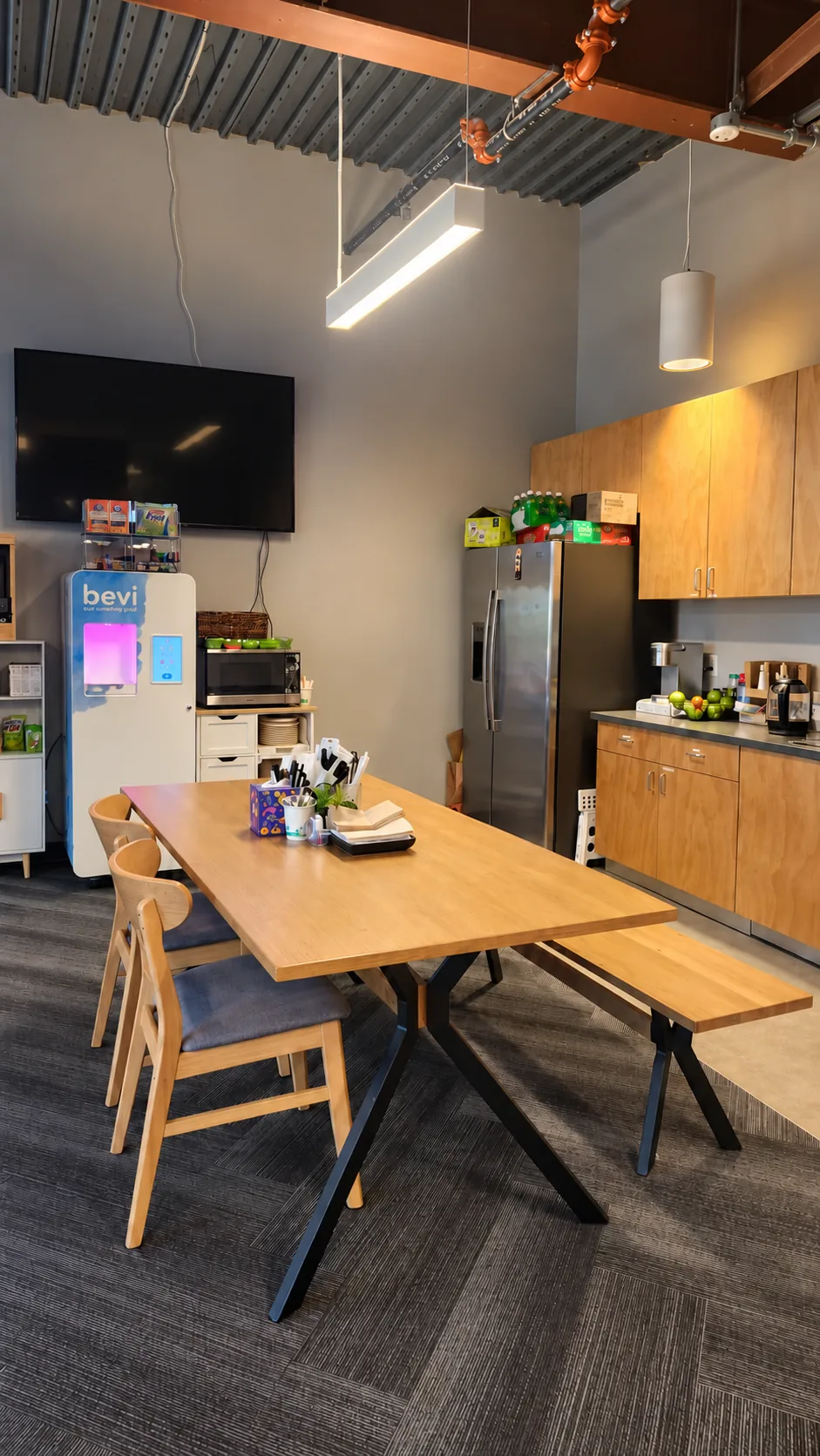 Suite 250 kitchenette with dining table, refrigerator and cabinetry